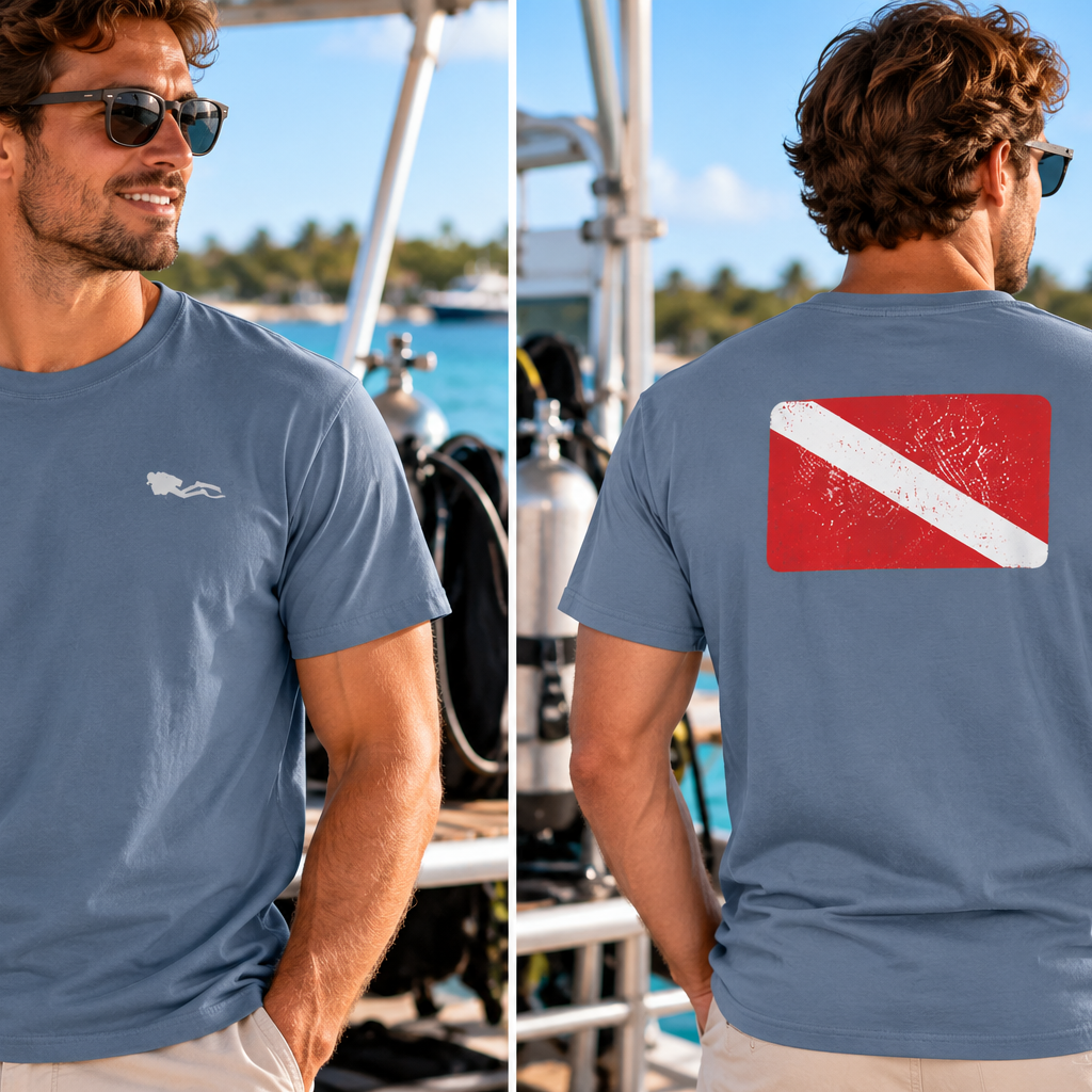 A man wearing a slate blue t-shirt with a small white logo on the left chest and a red and white diver flag graphic on the back, shown in front and back views against a boat deck and ocean background.